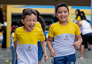 Dois meninos de camisa amarela descendo escadas correndo, cheios de motivação.