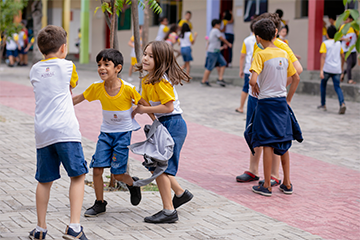 Um grupo de crianças participando das atividades do Minha Vida Educação Sociemocional enquanto brincava na calçada.