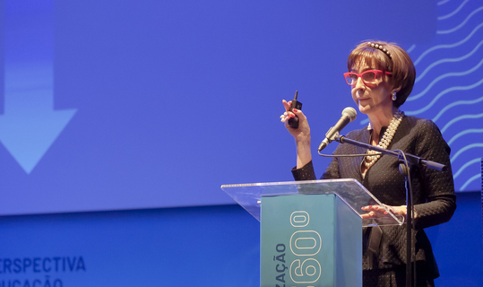 Uma mulher fazendo um discurso poderoso sobre "O Que Fazemos" em uma conferência.