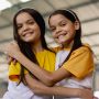 Duas meninas se abraçando em um estádio durante o McDia Feliz.