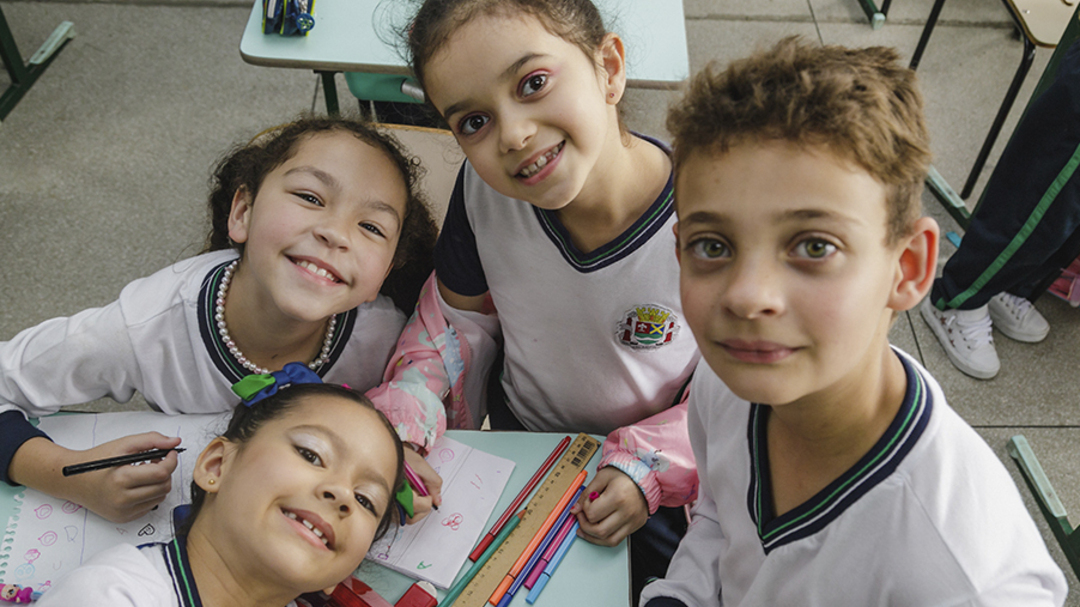 Um grupo de crianças posa para foto em uma sala de aula como parte da iniciativa Marketing de Causa promovida pelo Instituto Ayrton Senna.