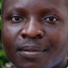 William Kamkwamba, um homem vestindo camisa branca e gravata.