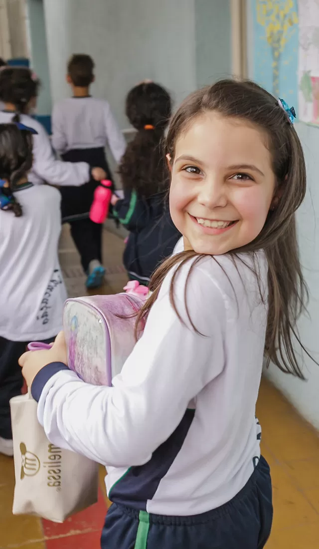 Uma jovem segurando uma lancheira cheia de Componentes Educacionais.
