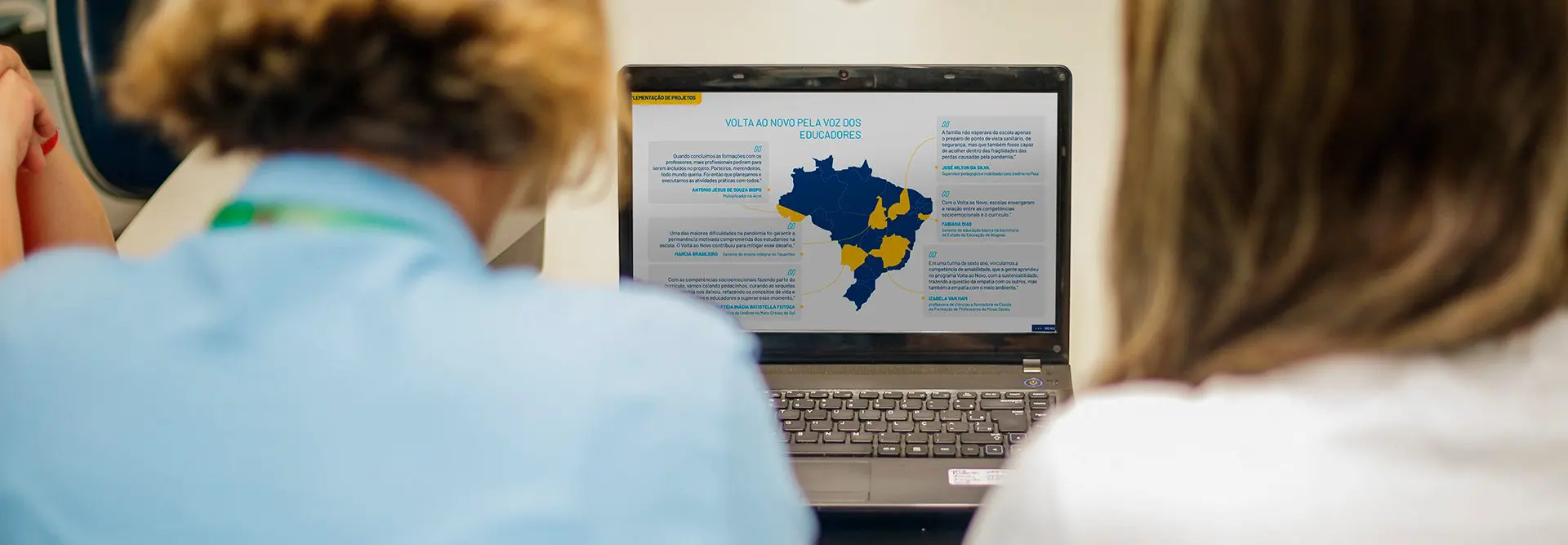 Pessoas vendo relatório na tela de um notebook