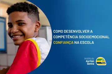 Estudante sorrindo em sala de aula apredendo sobre como desenvolver a confiança na escola.