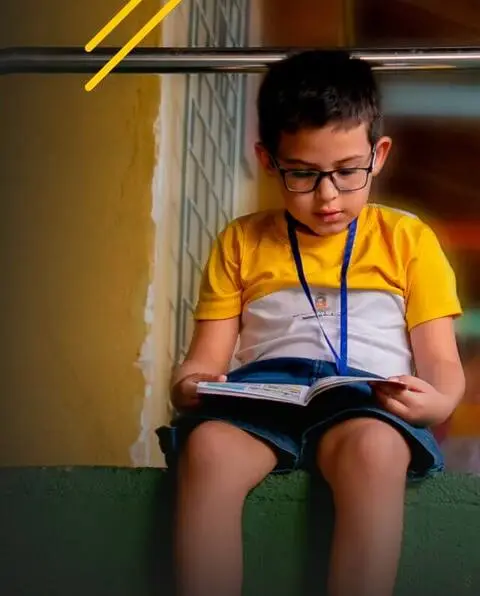 Um menino absorto em um livro no Instituto Ayrton Senna.