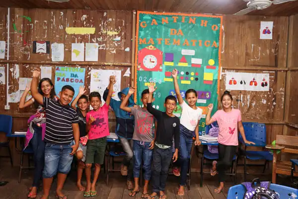 Grupo de crianças comemorando que realizaram as atividades de alfabetização.