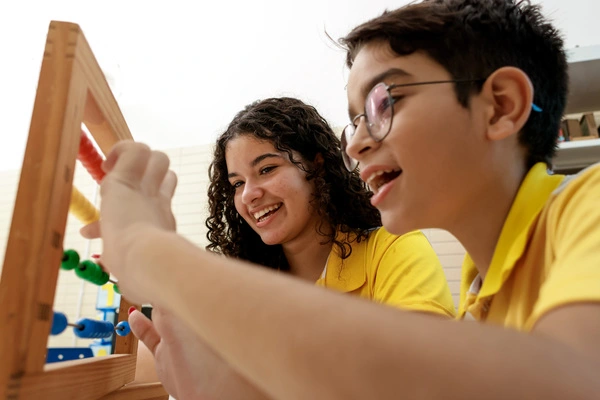 Duas crianças interagindo no ambiente escolar provando a importância do setembro amarelo