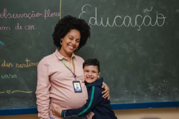 Estudante abraça professora em sala de aula, simbolizando impacto do investimento social privado na educação pública e no desenvolvimento integral