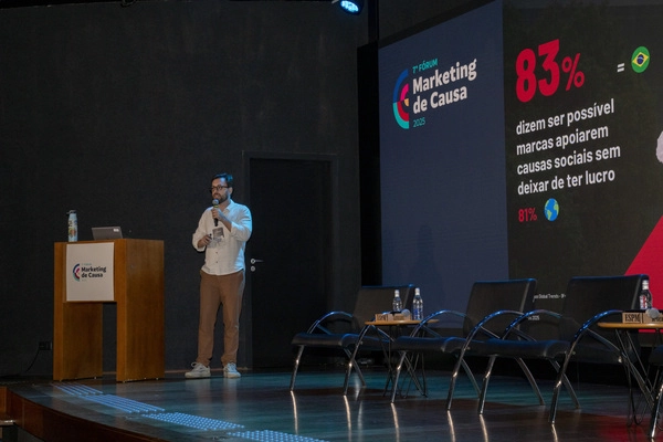 Pessoa em palco apontando para dado de pesquisa de Marketing de Causa