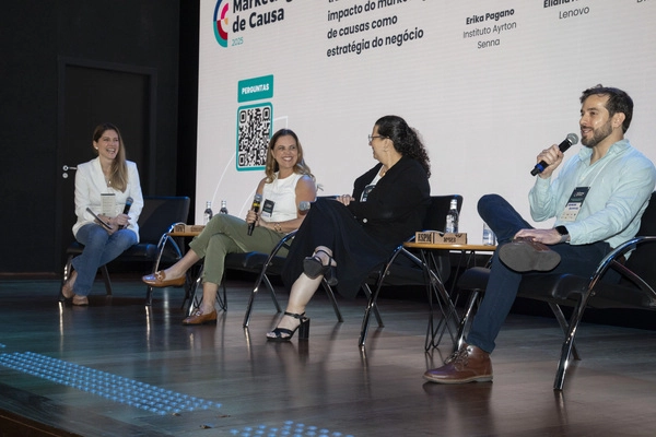 Pessoas sentadas sorrindo debatendo sobre marketing de causa.