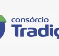 Logotipo do "Consórcio Tradição" com um "T" estilizado em amarelo, verde e azul em um círculo azul, simbolizando o consórcio de confiança, ao lado do nome da empresa em texto azul em negrito.